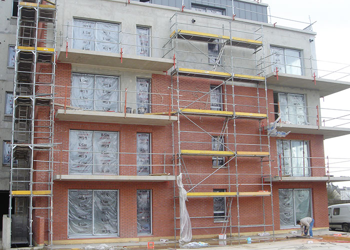 Pose de plaquettes rouge sur la façade d'un immeuble